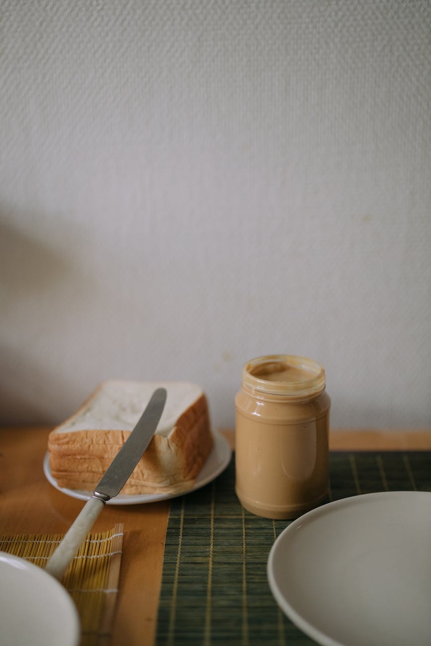 peanut butter container beside pile of bread